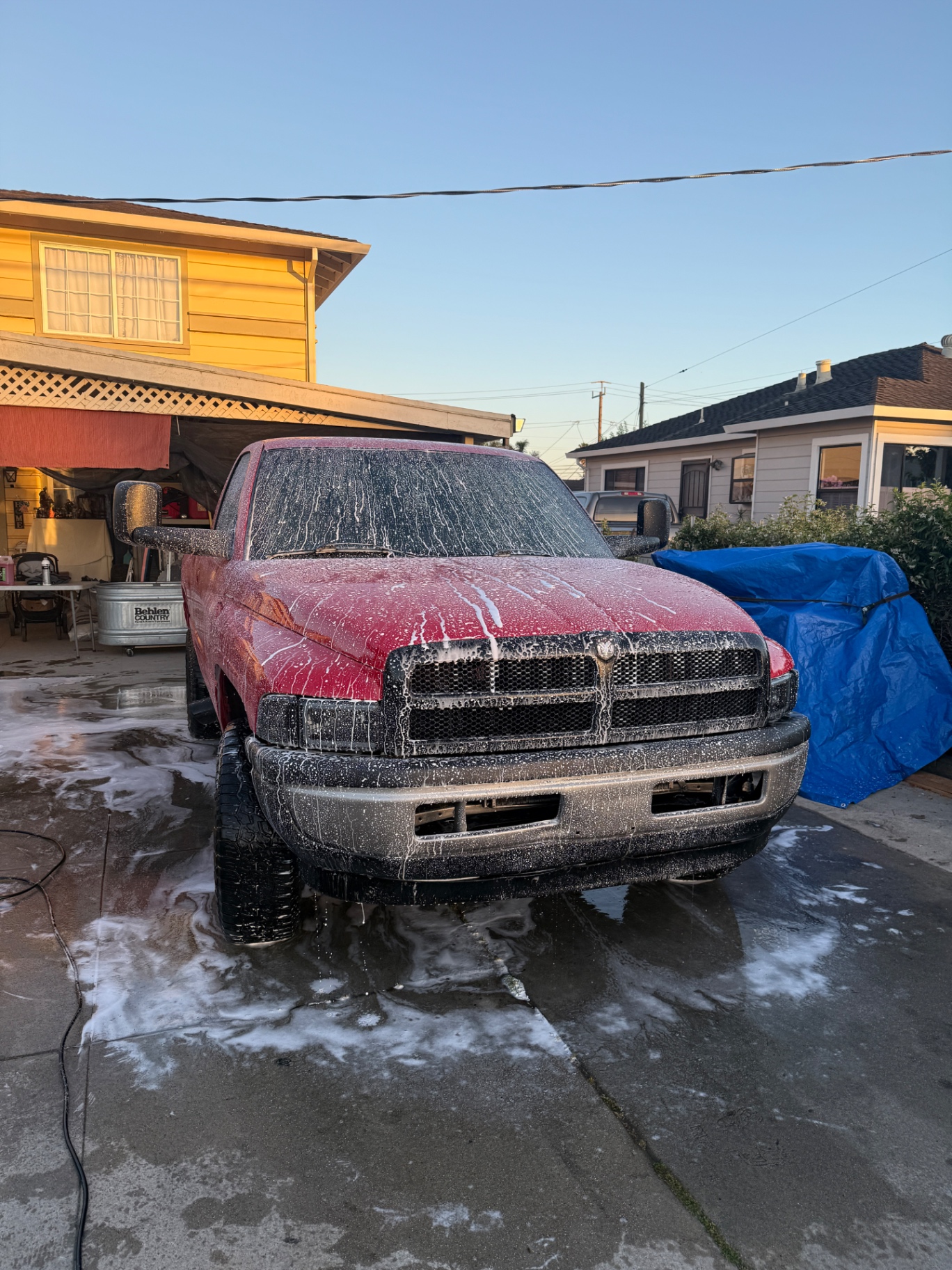 Red Dodge Ram truck covered in foam during wash