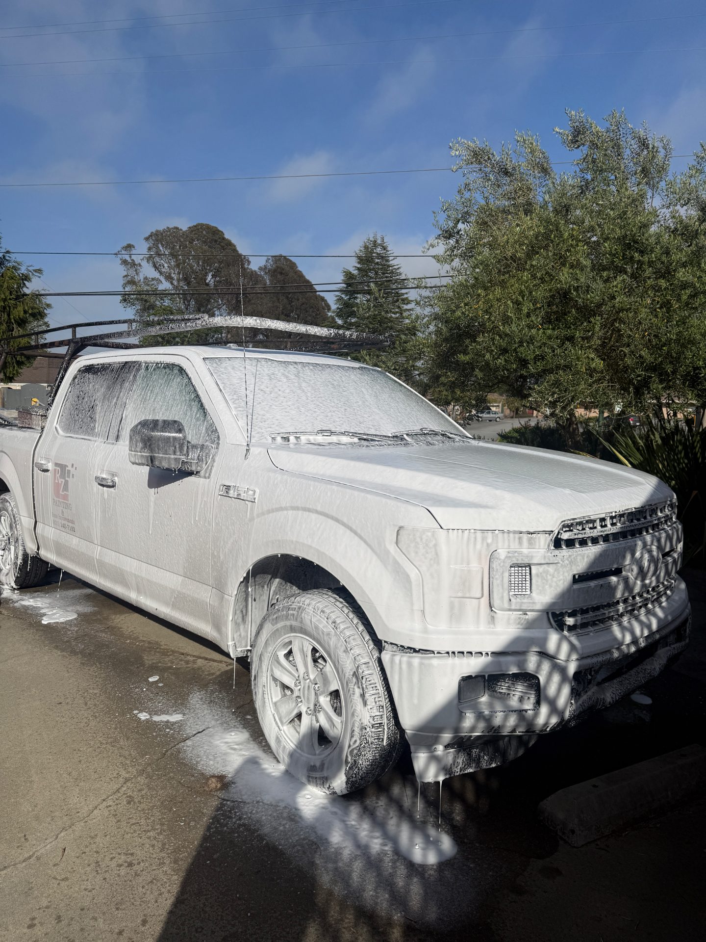 White Ford F-150 covered in foam during wash