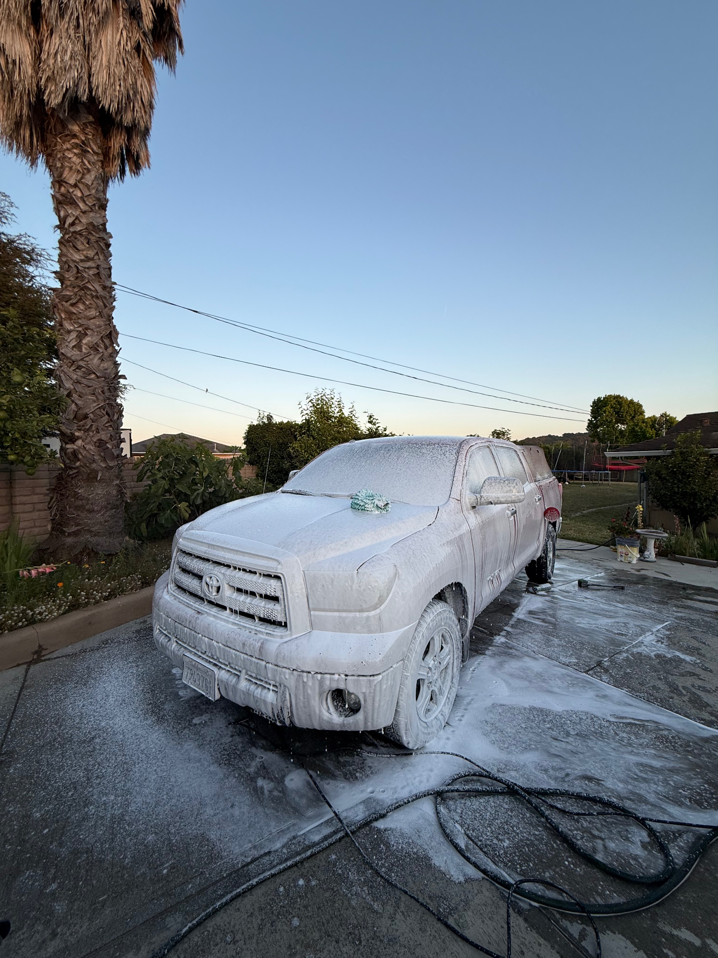 Toyota Tundra covered in foam during wash at sunset